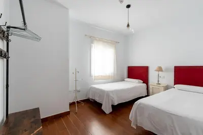 a white room with two beds and a window at Sanlúcar Olehousing in Sanlúcar de Barrameda