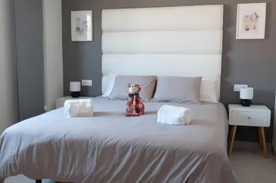 a teddy bear sitting on top of a bed at Loft con Piscina ADULTS ONLY in Chiclana de la Frontera