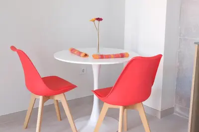 two red chairs sitting next to a white table at Loft con Piscina ADULTS ONLY in Chiclana de la Frontera
