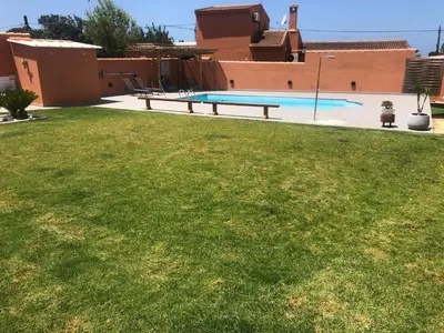 a backyard with a swimming pool and a grass yard at Loft con Piscina ADULTS ONLY in Chiclana de la Frontera