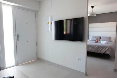 a living room with a tv on a wall at Loft con Piscina ADULTS ONLY in Chiclana de la Frontera