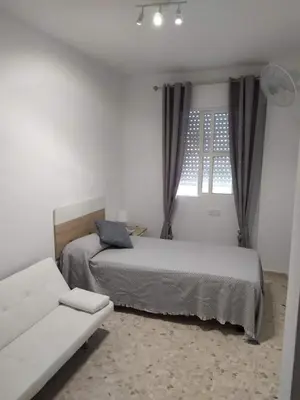 a bedroom with two beds and a couch and a window at Luz y Sol San Fernando in San Fernando