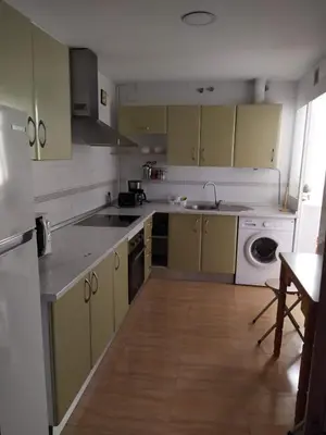 a kitchen with yellow cabinets and a sink and a dishwasher at Luz y Sol San Fernando in San Fernando