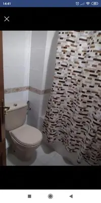 a bathroom with a toilet and a shower curtain at Luz y Sol San Fernando in San Fernando