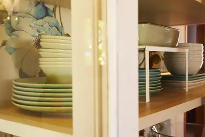 a shelf full of plates and bowls on a shelf at Villa Ada con Piscina, Jardin y Parking 9,3 in Chiclana de la Frontera