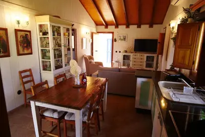 a kitchen and living room with a table and a couch at Villa Ada con Piscina, Jardin y Parking 9,3 in Chiclana de la Frontera
