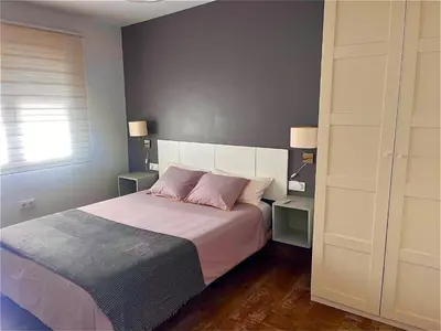 a bedroom with a large bed with two pink pillows at Apartamento con Piscina ADULTS ONLY in Chiclana de la Frontera