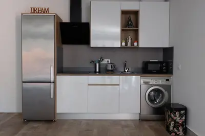 a kitchen with a refrigerator and a washing machine at Apartamento con Piscina ADULTS ONLY in Chiclana de la Frontera