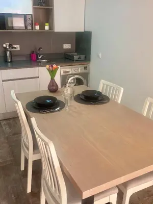 a dining room table with chairs and a kitchen at Apartamento con Piscina ADULTS ONLY in Chiclana de la Frontera