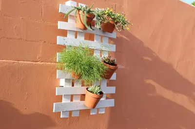 a white wall with potted plants on it at Apartamento con Piscina ADULTS ONLY in Chiclana de la Frontera
