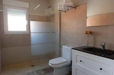 a bathroom with a toilet and a sink and a window at Apartamento con Piscina ADULTS ONLY in Chiclana de la Frontera