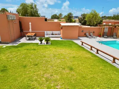 a backyard with a lawn and a swimming pool at Apartamento con Piscina ADULTS ONLY in Chiclana de la Frontera