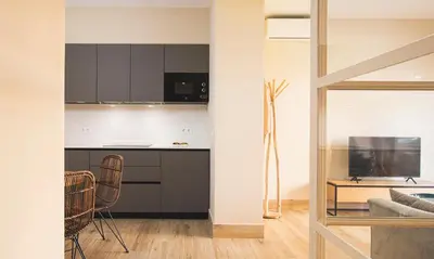 a kitchen and living room with a table and chairs at Terraza Playa de Cádiz 1 Ha Apartment in Cádiz