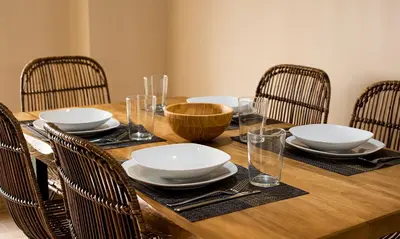 a wooden table with chairs and plates and glasses on it at Terraza Playa de Cádiz 2 Ha Apartment in Cádiz