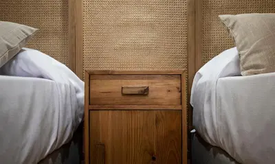 a wooden cabinet between two beds in a room at Terraza Playa de Cádiz 2 Ha Apartment in Cádiz