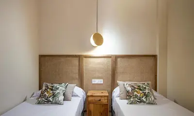 a bedroom with two beds with white sheets at Terraza Playa de Cádiz 2 Ha Apartment in Cádiz