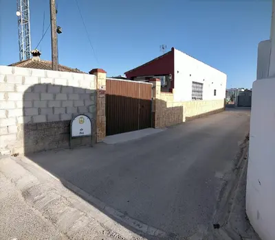 an empty street next to a building with a gate at Apartamento Fez playa de la barrosa in Chiclana de la Frontera