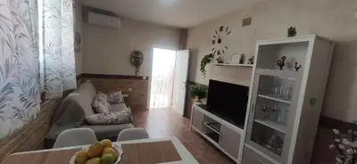 a living room with a couch and a television at Apartamento Fez playa de la barrosa in Chiclana de la Frontera