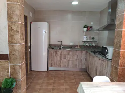 a kitchen with a white refrigerator in a room at Apartamento Fez playa de la barrosa in Chiclana de la Frontera