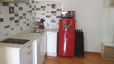 a kitchen with a red refrigerator with a microwave on top at Apartamento Helena in Rota