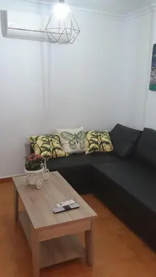 a black couch in a living room with a table at Apartamento Helena in Rota