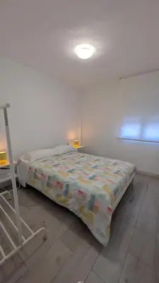 a bed in a white room with a bed frame at Playa y Sol Grupo AC Gestion in Cádiz