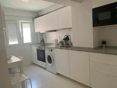 a white kitchen with a washing machine in it at Playa y Sol Grupo AC Gestion in Cádiz