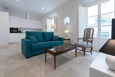 a living room with a blue couch and a table at Apartamento Cadiz Wonderland in Cádiz