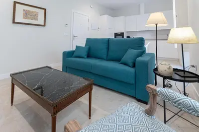 a living room with a blue couch and a coffee table at Apartamento Cadiz Wonderland in Cádiz