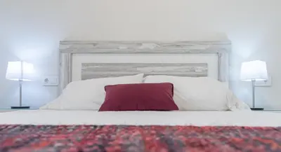 a bedroom with a white bed with a red pillow at Apartamento Cadiz Wonderland in Cádiz