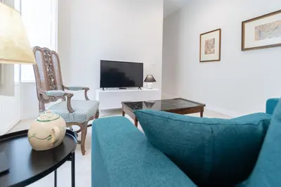 a living room with blue furniture and a tv at Apartamento Cadiz Wonderland in Cádiz