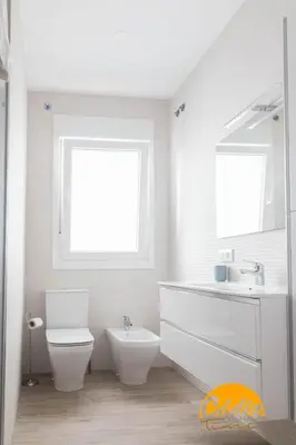 a bathroom with a toilet and a sink and a window at Casa del Fotografo by Cadiz Time in Cádiz