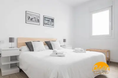 a white bedroom with a white bed and a window at Casa del Fotografo by Cadiz Time in Cádiz