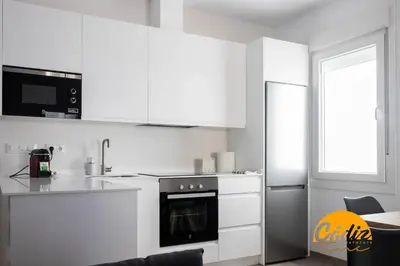 a kitchen with white cabinets and a stove top oven at Casa del Fotografo by Cadiz Time in Cádiz
