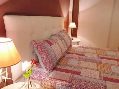 a bedroom with a bed with a pillow and flowers at Sherryflat La Estación - Parking in Jerez de la Frontera