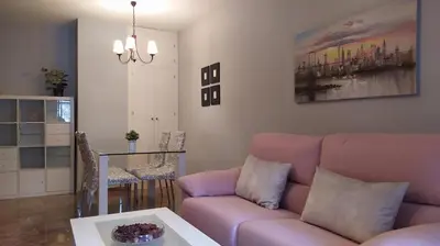 a living room with a pink couch and a table at Sherryflat La Estación - Parking in Jerez de la Frontera