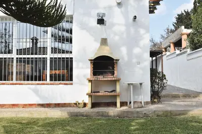 a white building with a bell on the side of it at Villa María Elena, en Fuente del Gallo in Conil de la Frontera