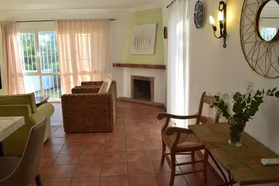 a living room with a table and a fireplace at Villa María Elena, en Fuente del Gallo in Conil de la Frontera