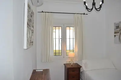 a bedroom with a bed and a window at Villa María Elena, en Fuente del Gallo in Conil de la Frontera