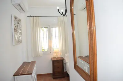 a bathroom with a mirror and a wooden table at Villa María Elena, en Fuente del Gallo in Conil de la Frontera