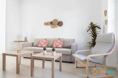 a living room with a couch and a chair at Apartamento Floral by LiveWork in Cádiz