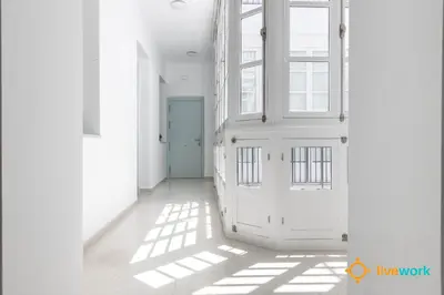 a hallway with white walls and a blue door at Apartamento Floral by LiveWork in Cádiz