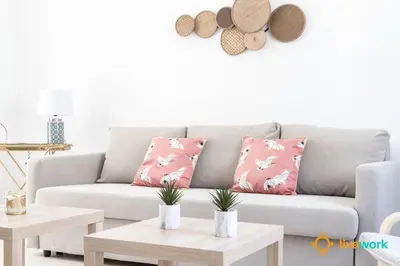 a living room with a gray couch with pink pillows at Apartamento Floral by LiveWork in Cádiz