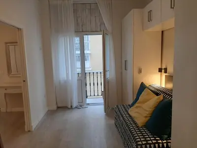 a living room with a couch and an open door at La esquina de los italianos by Gades Gestión in Cádiz