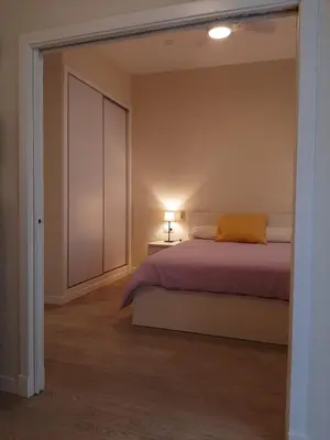 a bedroom with a bed and a closet and a lamp at La esquina de los italianos by Gades Gestión in Cádiz