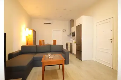 a living room with a blue couch and a table at La esquina de los italianos by Gades Gestión in Cádiz