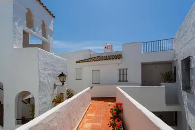 a white house with white walls and a walkway at Barrosa Frente al Mar in Chiclana de la Frontera