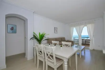 a white dining room with a white table and chairs at Barrosa Frente al Mar in Chiclana de la Frontera