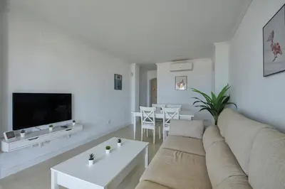 a white living room with a couch and a table at Barrosa Frente al Mar in Chiclana de la Frontera