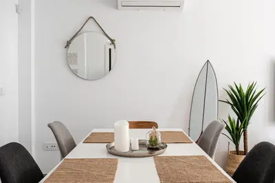 a dining room with a table and a mirror at CASA LA PLAYA-CONIL Vacaciones de Lujo en Conil con Todas las Comodidades NETFLIX-HBO-DISNEY-CANALES DE FUTBOL-WIFI ALTA VELOCIDAD-SMART TV 65